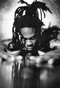 a man with dreadlocks sitting at a table in front of a glass bowl