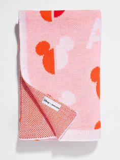 a pink and orange blanket with hearts on it, folded to show the back side