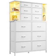 a tall white cabinet with yellow lights on the top and bottom drawers in front of it