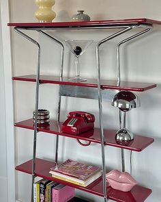 a red shelf with some books and other items on it