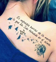 the back of a woman's shoulder with a quote written in spanish and dandelions