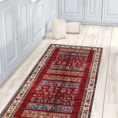 a red area rug in a kitchen with white cabinets