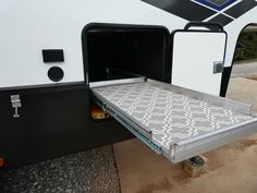 an rv with the door open and its bed pulled out