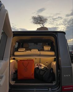 the back end of a van with luggage in it's trunk and an orange bag