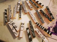 several different types of wooden clothes pins on a table with papers and scissors in the background