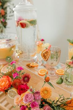 the table is set with flowers, lemons and oranges for an elegant dinner