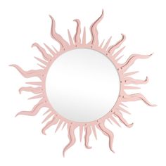 a pink sun shaped mirror sitting on top of a white wall