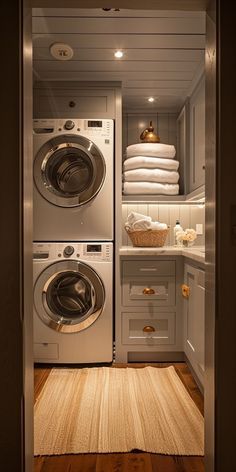 a washer and dryer in a small room next to each other with towels on the shelves