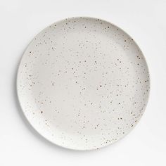 an empty white plate with gold speckles on the rim, against a white background