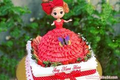 a birthday cake with a doll on top