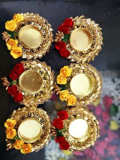 four candles are sitting on top of each other with red, yellow and orange flowers