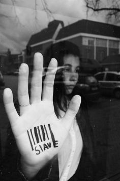 a woman is holding up her hand with the word slave written on it in black and white