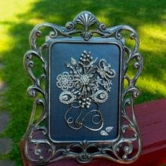 a metal frame sitting on top of a red bench in front of a grass covered park