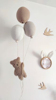 a teddy bear hanging from the ceiling with balloons attached to it's strings and birds flying around