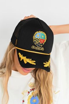 The Herald Crest Trucker Hat features a detailed, multicolored embroidered crest design with rich gold detailing across the brim. Thick, embroidered design Wide brimmed for trucker fit or bendable for baseball cap fit Adjustable snap back closure All accessories are final sale for sanitary purposes. Your order will ship from our warehouse in Florida, USA! Embroidered Gold Cap Hat, Gold Snapback Hat One Size, Gold One Size Snapback Baseball Cap, Gold Embroidered Cap Hat, Gold Embroidered Cap, Gold Adjustable Trucker Hat, Adjustable Gold Trucker Hat, Casual Gold Trucker Hat With Curved Brim, Gold Snapback Trucker Hat