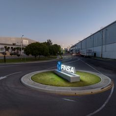 an empty parking lot in front of a large building with the word finsa on it