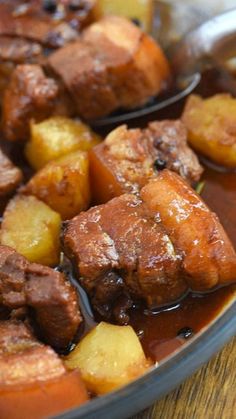 some meat and potatoes are in a bowl with sauce on the side, ready to be eaten