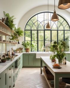 an instagramted photo of a kitchen with green cabinets and white countertops, surrounded by large arched windows