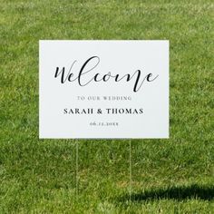 a welcome sign in the grass for someone to have their wedding written on it with black ink