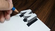 someone is drawing letters with pencils on top of a piece of paper that has been folded