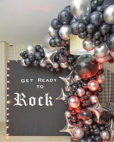 a sign that says get ready to rock surrounded by balloons