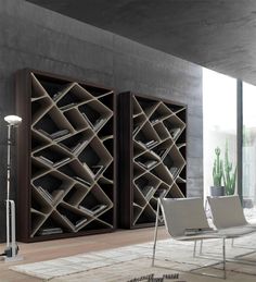 two bookshelves in the middle of a room with white chairs and rugs