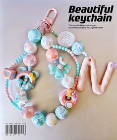 the front cover of beautiful keychain magazine with beads and charms on it's side