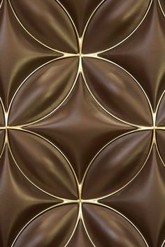 a close up view of chocolate colored leather with gold lines and circles on the surface