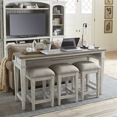 a living room filled with furniture and a flat screen tv on top of a wooden table