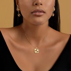 a close up of a woman wearing a necklace and earring with a soccer ball on it