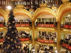 a large christmas tree is in the middle of a building with many balconies