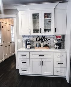 a kitchen with white cabinets and stainless steel appliances in the center, along with a coffee maker on the counter