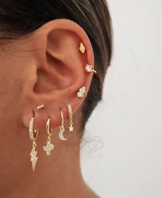 a woman's ear with three different types of earrings