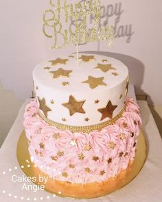 a birthday cake with pink frosting and gold stars