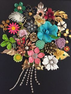 a bunch of flowers that are on top of a black surface with pearls and beads