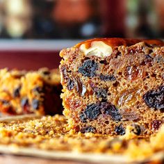 a piece of cake with raisins and nuts on it sitting on a plate