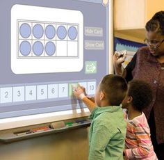 a woman teaching children how to write on a whiteboard