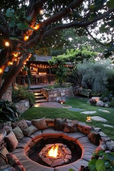 an outdoor fire pit surrounded by rocks and lights