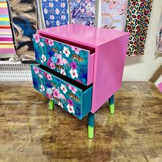 a pink and blue dresser sitting on top of a wooden floor