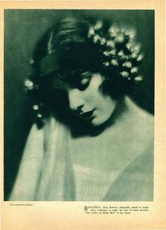 an old photo of a woman with flowers in her hair