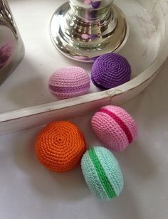 three crocheted balls sitting on top of a table next to a tea pot