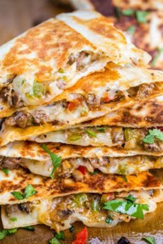 a stack of quesadillas stacked on top of each other with cheese and meat