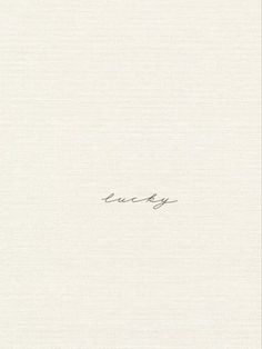 the word lucky is written in cursive ink on a white paper with black writing