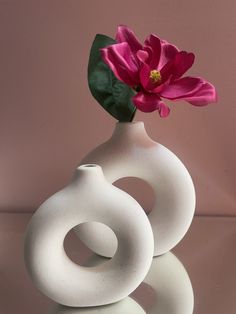 two white vases with pink flowers in them