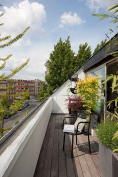 a balcony with chairs and plants on it