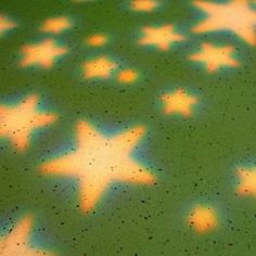 stars are projected on the floor in front of a green surface with yellow and blue colors