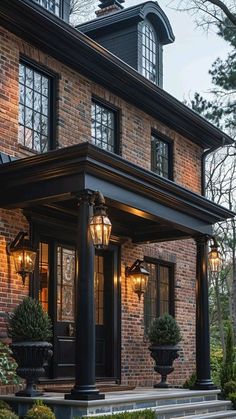 a brick house with black columns and lights