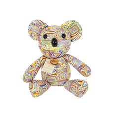 a multicolored teddy bear sitting up against a white background