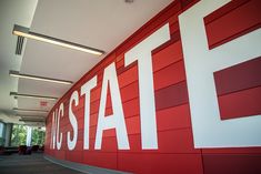 a red and white wall with the word sat on it in front of a building