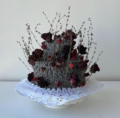 there is a cake that has flowers on it and branches in the middle of it